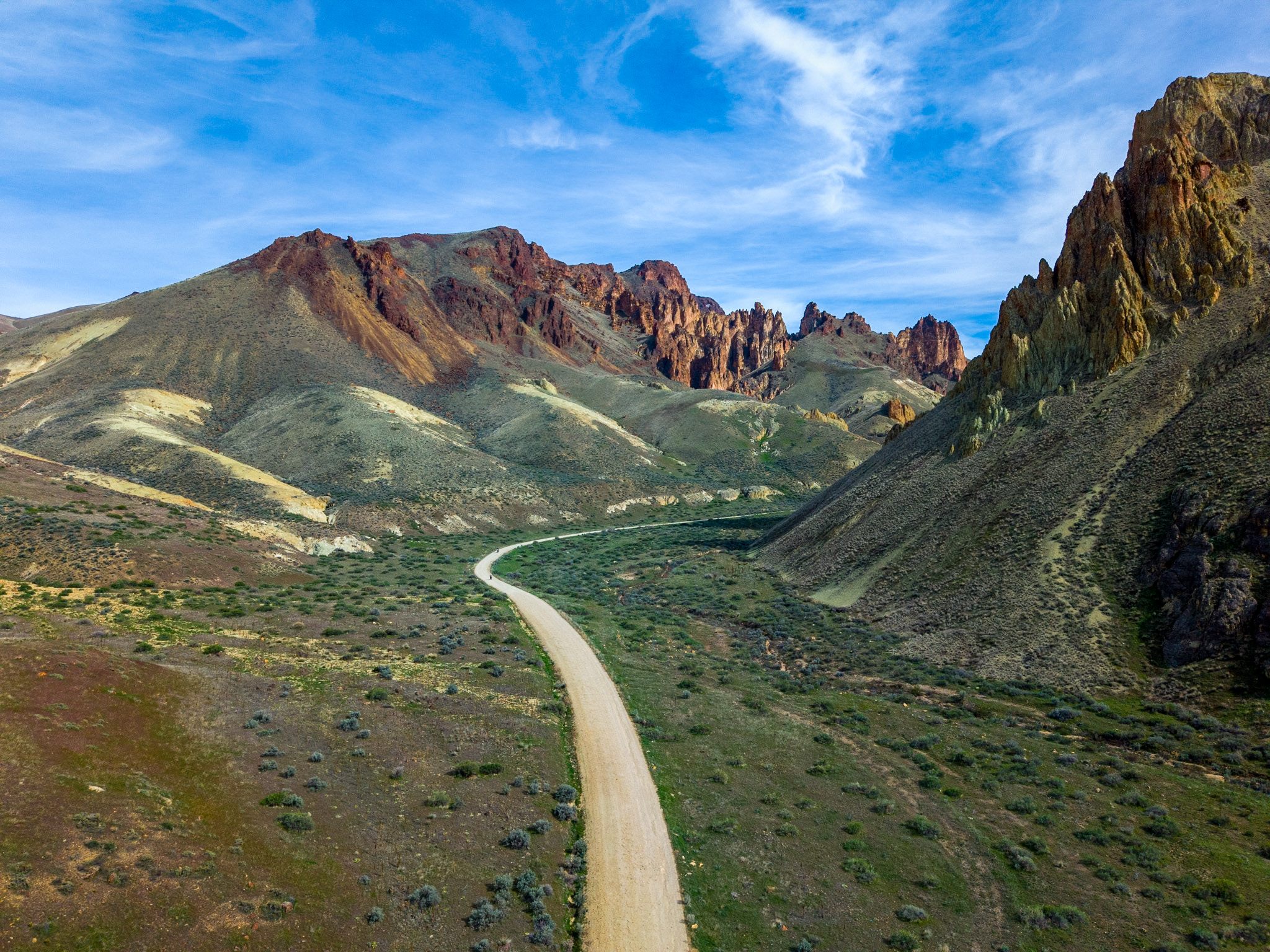 Gravel road winding through the colorful rock formations of Leslie Gulch, Oregon